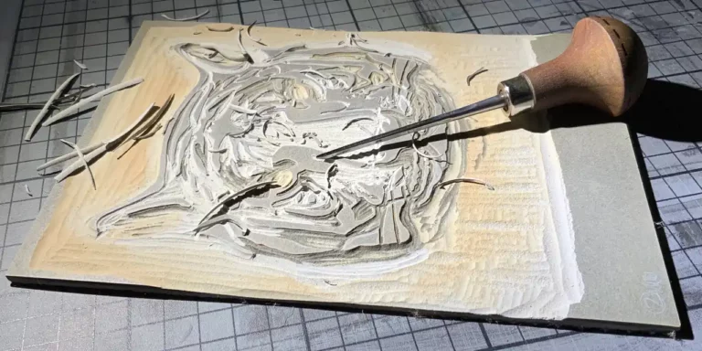 Linoleumplatte mit eingeritztem Motiv, Linolmesser und Spänen