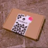 Das in einen kleinen Karton verpackte Textildruck-Set liegt auf einem Steinboden.