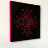 Seitenansicht des Mandala-Holzschnittes, auf dem der Rand der Holzplatte zu sehen ist, die Neon-Pink angemalt wurde.
