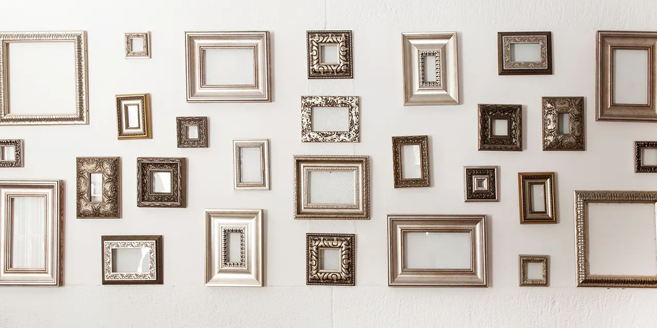 Viele unterschiedliche kleine und große Bilderrahmen hängen an einer Wand
