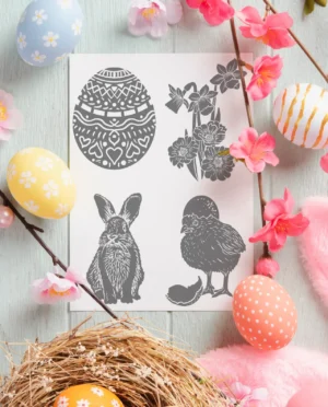 Linoldruck-Vorlagen-Set "Ostern" ausgedruckt auf einem weißen Holztisch, drumherum bunte Zweige und Ostereier dekoriert